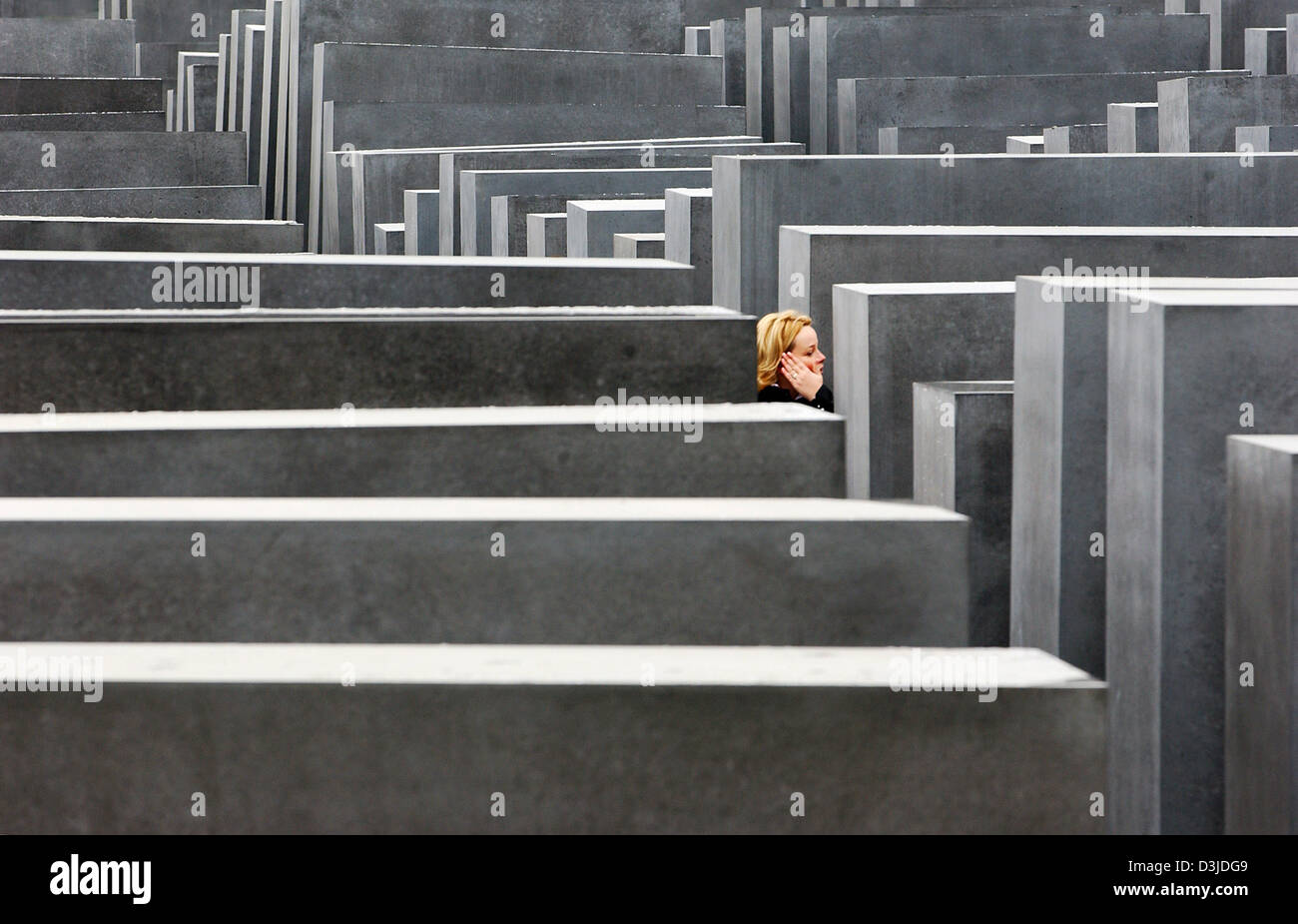 (Dpa) - Un visitatore passeggiate tra le colonne di blocchi in calcestruzzo presso il Memoriale dell'Olocausto sito in Berlino, giovedì, 12 maggio 2005. Dopo anni di preparativi il memoriale per gli ebrei assassinati d'Europa, è stata ora aperta al pubblico. Foto Stock
