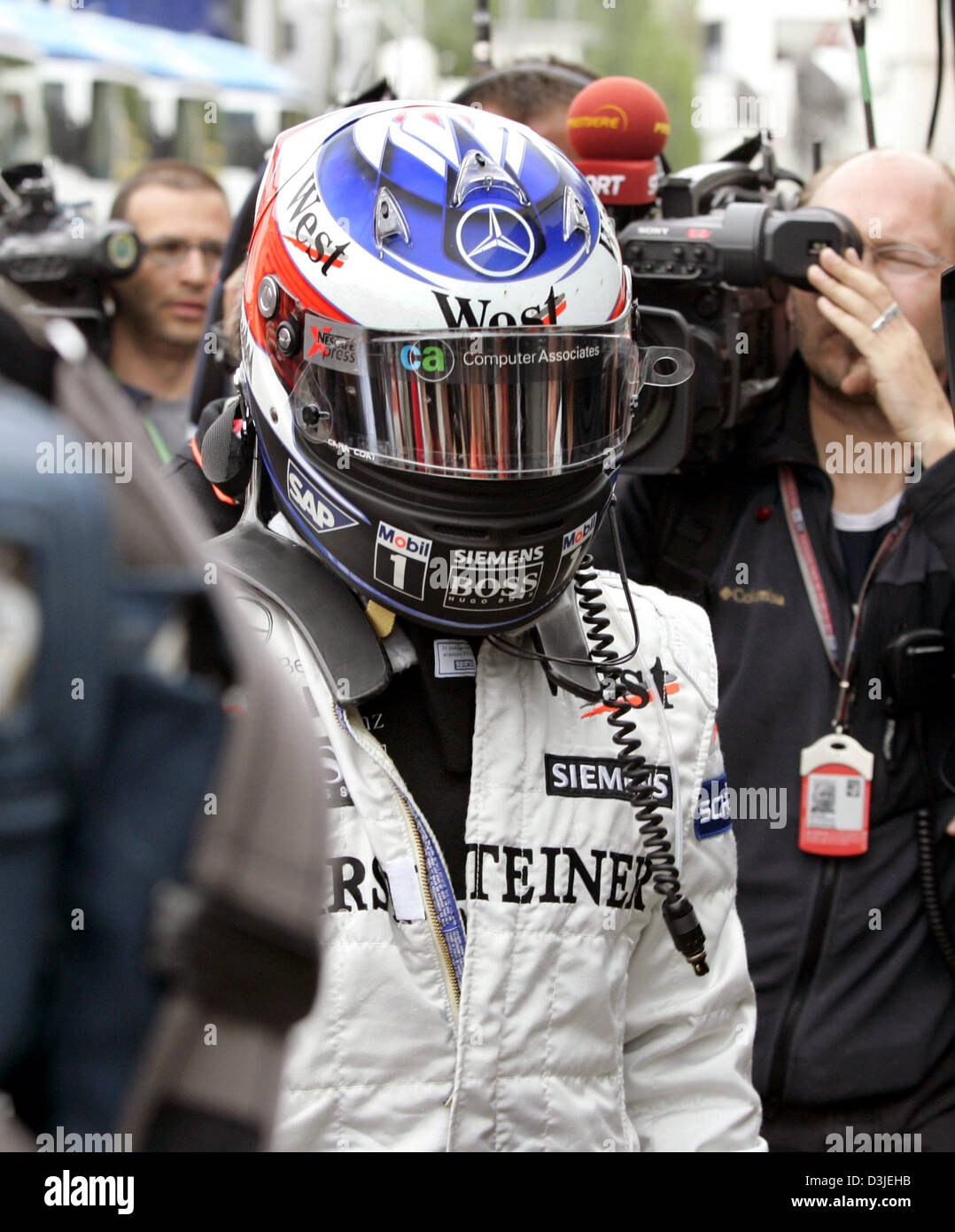 (Dpa) - Finlandese pilota di Formula Uno Kimi Raeikkoenen (L) passeggiate attraverso il paddock che indossa ancora il suo casco dopo droping della gara nel Gran Premio di San Marino di Imola, Italia, 24 aprile 2005. Foto Stock