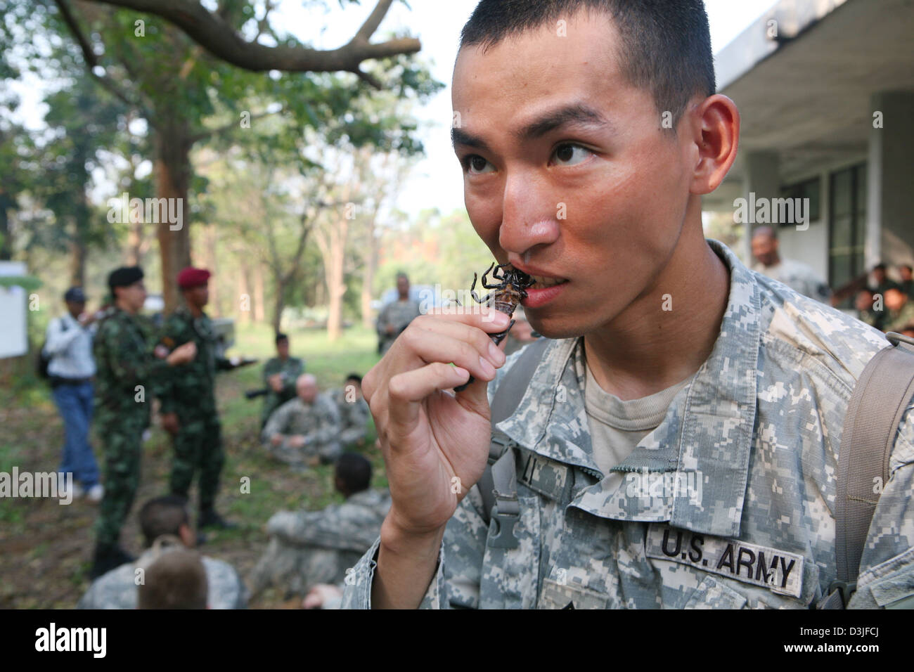 Un marine statunitense mangia uno scarafaggio arrosto durante una giungla corso di sopravvivenza Febbraio 16, 2013 in Ban Chan Krem, Thailandia. La classe insegna Marines giungla di base delle tecniche di sopravvivenza come parte di esercizio Cobra Gold 2013. Foto Stock