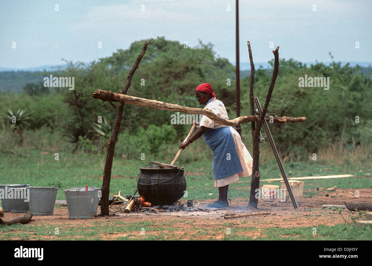 Un cuoco della scuola che prepara pasti gratuiti fuori della scuola, pagati dalla carità britannica, in una scuola elementare rurale. Siphofaneni, Eswatini (Swaziland) Foto Stock