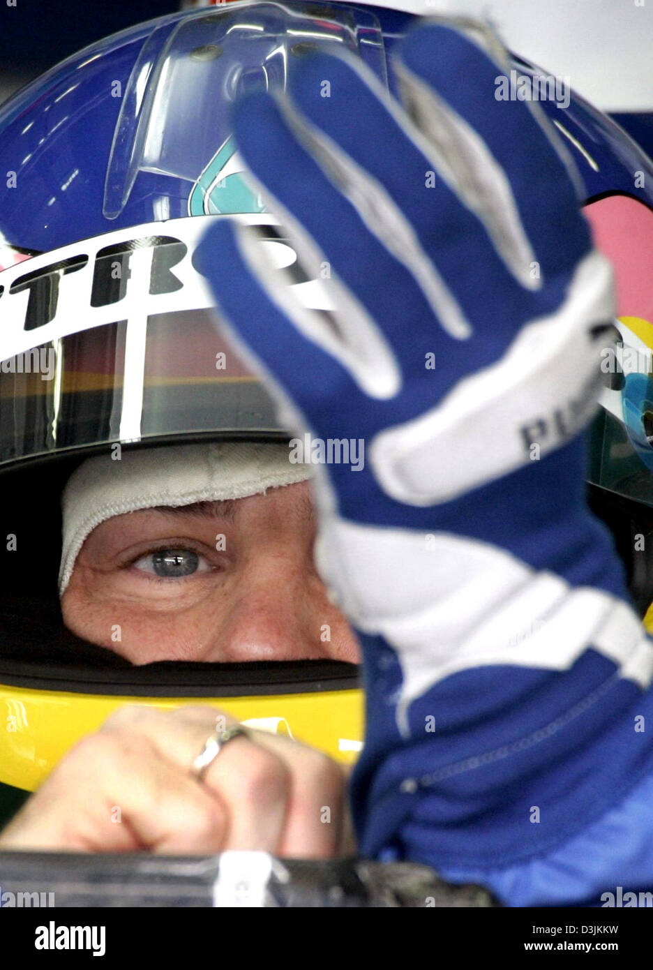 (Dpa) - canadese driver di Formula Uno Jacques Villeneuve mette sulla sua guanti durante la sessione di formazione presso il Gran Premio della Malesia circuito di Sepang, vicino a Kuala Lumpur, Malesia, 18 marzo 2005. Villeneuve cadenzato il diciottesimo miglior tempo. Voci esistenti che Villeneuve potrebbe essere sparato dalla Sauber team principal Peter Sauber. Il Gran Premio della Malesia ha luogo il 20 marzo 2005. Foto Stock