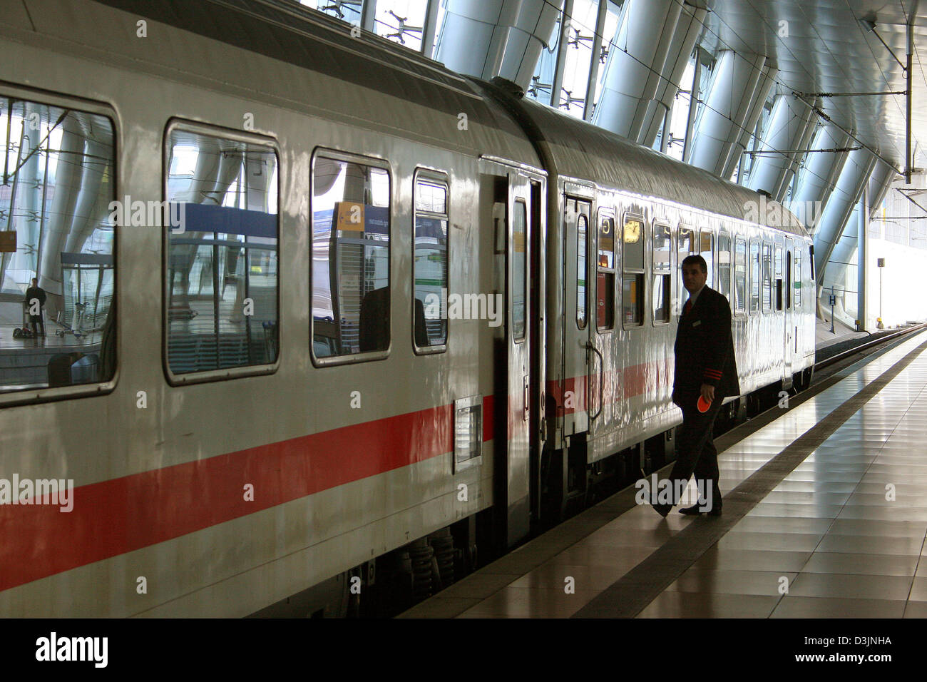 (Dpa) - Un treno conducter controlla la piattaforma prima della partenza di una lunga distanza servizio intercity alla stazione dei treni per servizi di trasporto ferroviario su lunga distanza all'aeroporto di Francoforte, Germania, 26 gennaio 2005. Foto Stock