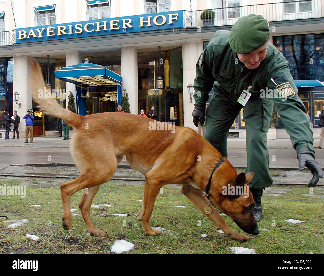 (Dpa) - un poliziotto le ricerche con il suo cane la zona anteriore del Bayerischer Hof (bavarese corte) a Monaco di Baviera, Germania, 11 febbraio 2005. La 41a conferenza di Monaco per la politica di sicurezza si svolgerà qui durante il weekend. Gli organizzatori si aspettano per la manifestazione centrale fino a 5 mila persone il 12 febbraio 2005. La polizia si aspettano meno manifestanti per quest'anno. La ragione principale è un Foto Stock