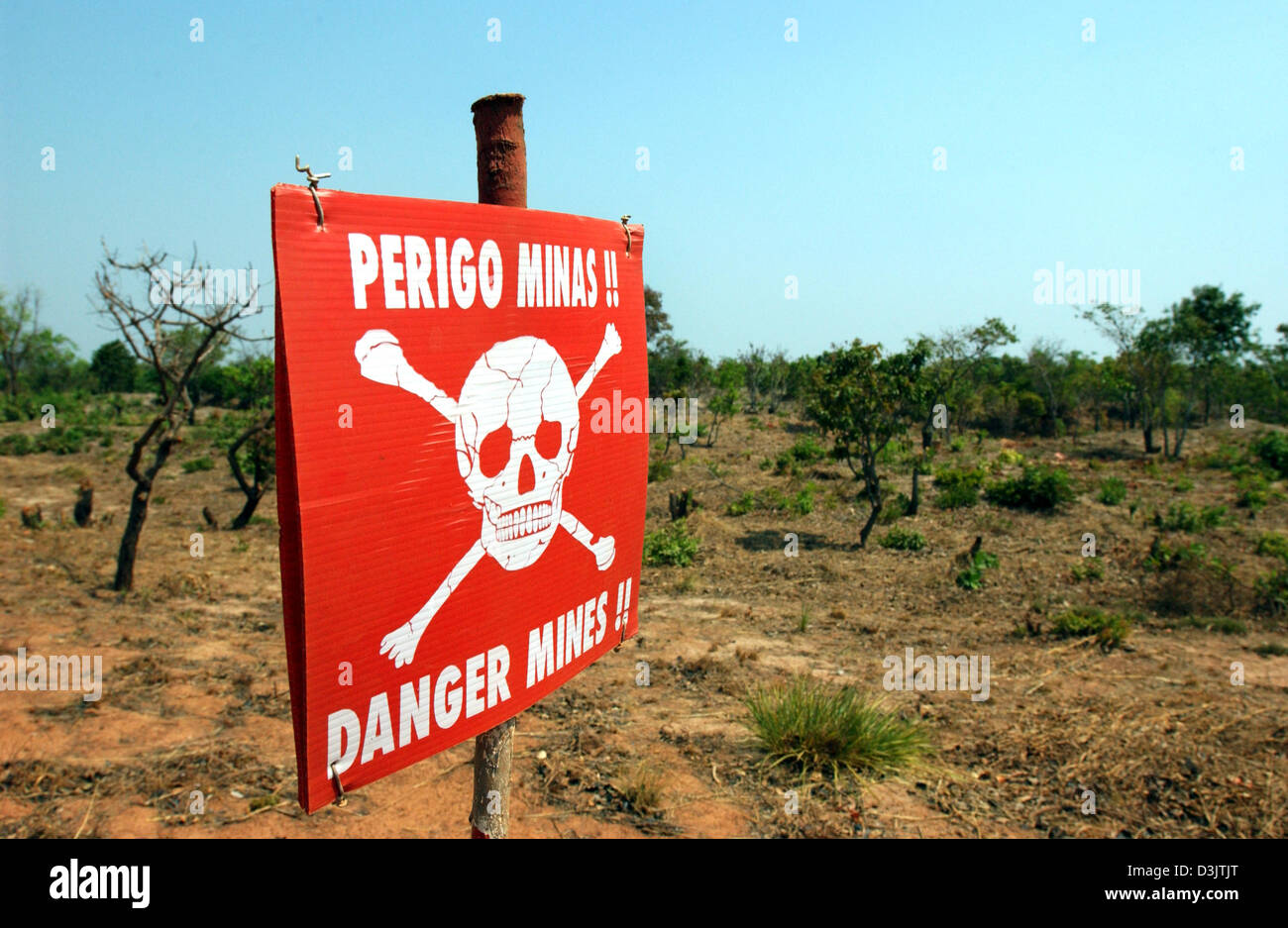 (Dpa) - Un Teschio e Ossa Croce segno indica i pericoli di un campo minato vicino a Kuningha vicino al totalmente distrutto capitale del distretto di Kuito, Angola, circa due ore di volo dalla capitale Luanda. Foto realizzata il 05 settembre, 2003. Fino ad oggi in Angola è pesantemente minate. Diverse organizzazioni hanno iniziato il lavoro di pericolose del disarmo di loro ma gli incidenti possono accadere tutto il tempo. Foto Stock