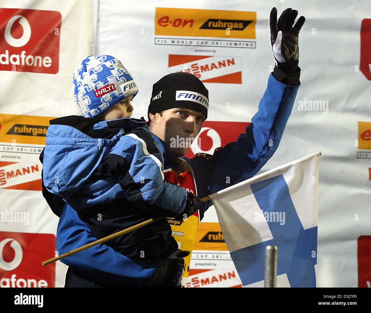 (Dpa) - finlandese ponticello sci Janne Ahonen onde mentre si tiene il suo figlio Mico sul suo braccio durante la 53a internazionale di quattro colli nel torneo di Bischofshofen, Austria, 6 gennaio 2005. Ahonen è stata in grado di rivendicare il titolo assoluto. Foto Stock