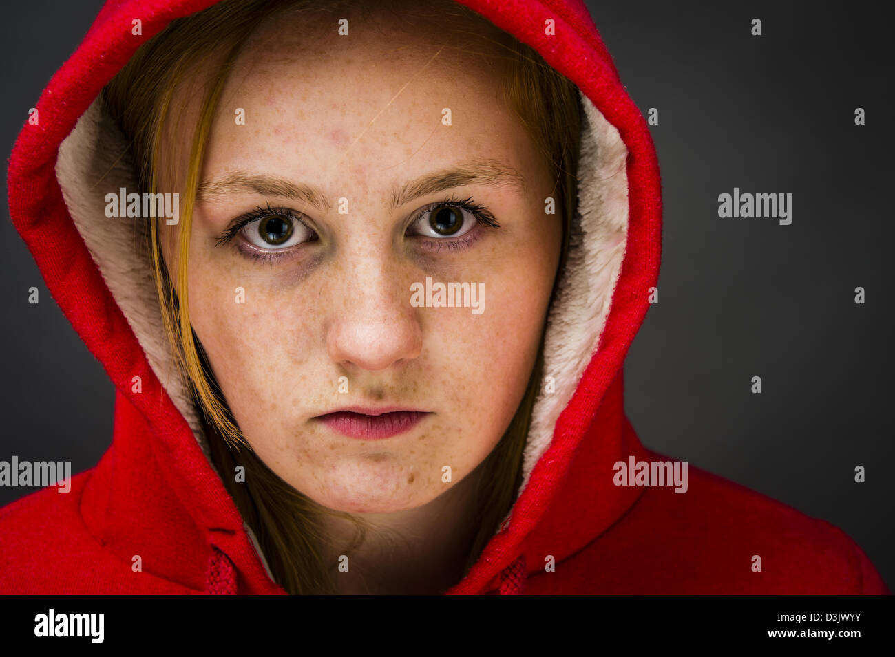 Un moody sulky 16, 17 anni dai capelli rossi freckle fronte ragazza adolescente, indossare una felpa con cappuccio REGNO UNITO Foto Stock