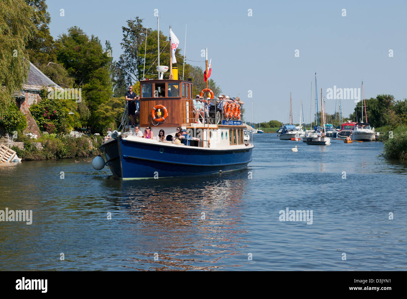 Una barca si avvicina la storica città mercato di Wareham sul fiume Frome. Foto Stock