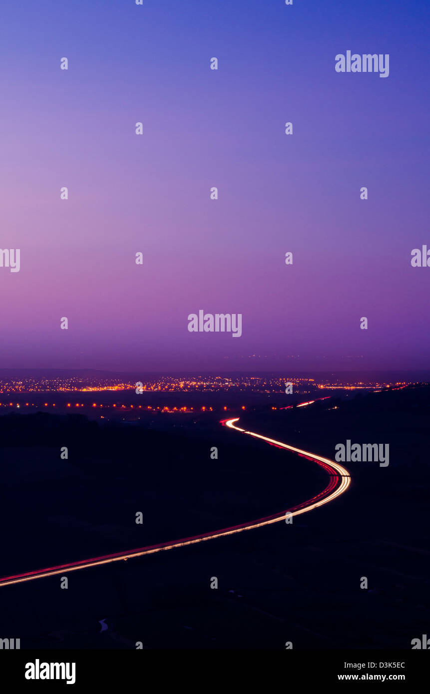 L'autostrada M5 e le spie di Weston-super-Mare visto dal truffatore picco sul Mendip Hills al crepuscolo, Somerset, Inghilterra. Foto Stock