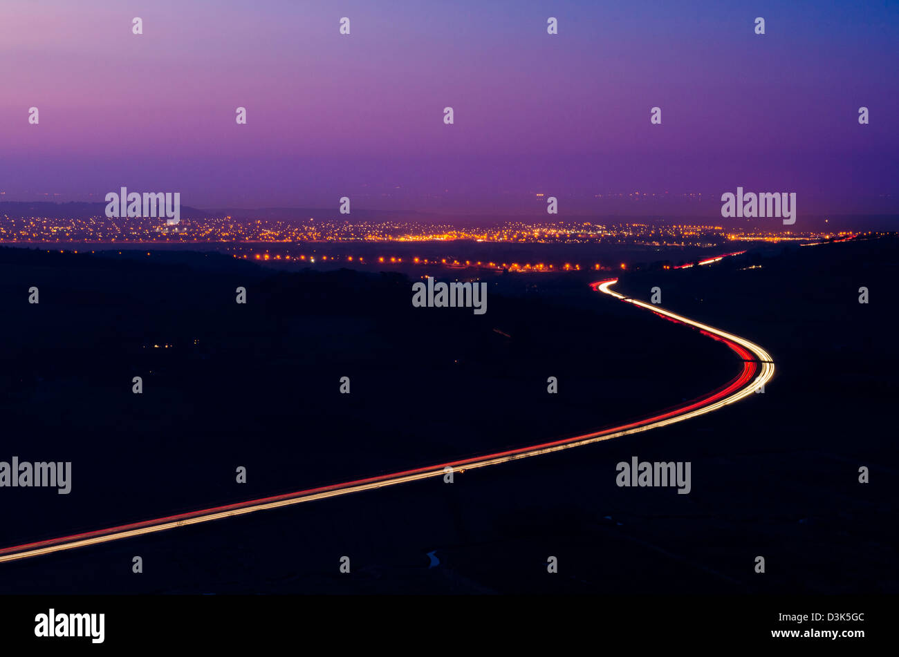 L'autostrada M5 e le spie di Weston-super-Mare visto dal truffatore picco sul Mendip Hills al crepuscolo, Somerset, Inghilterra. Foto Stock