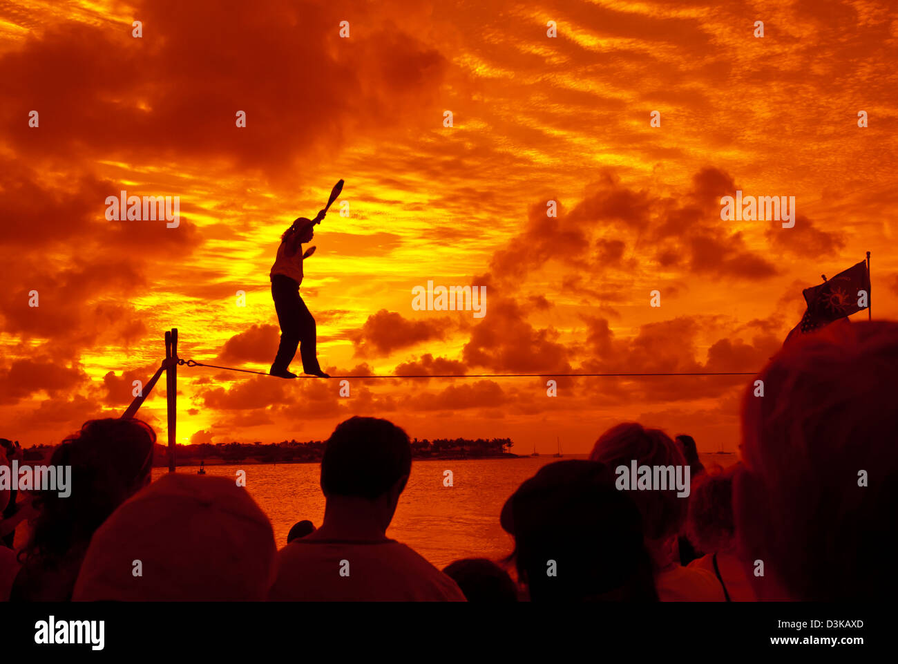Giocoliere tightrope passeggiate al tramonto celebrazione a Mallory Square, Key West, Florida Foto Stock
