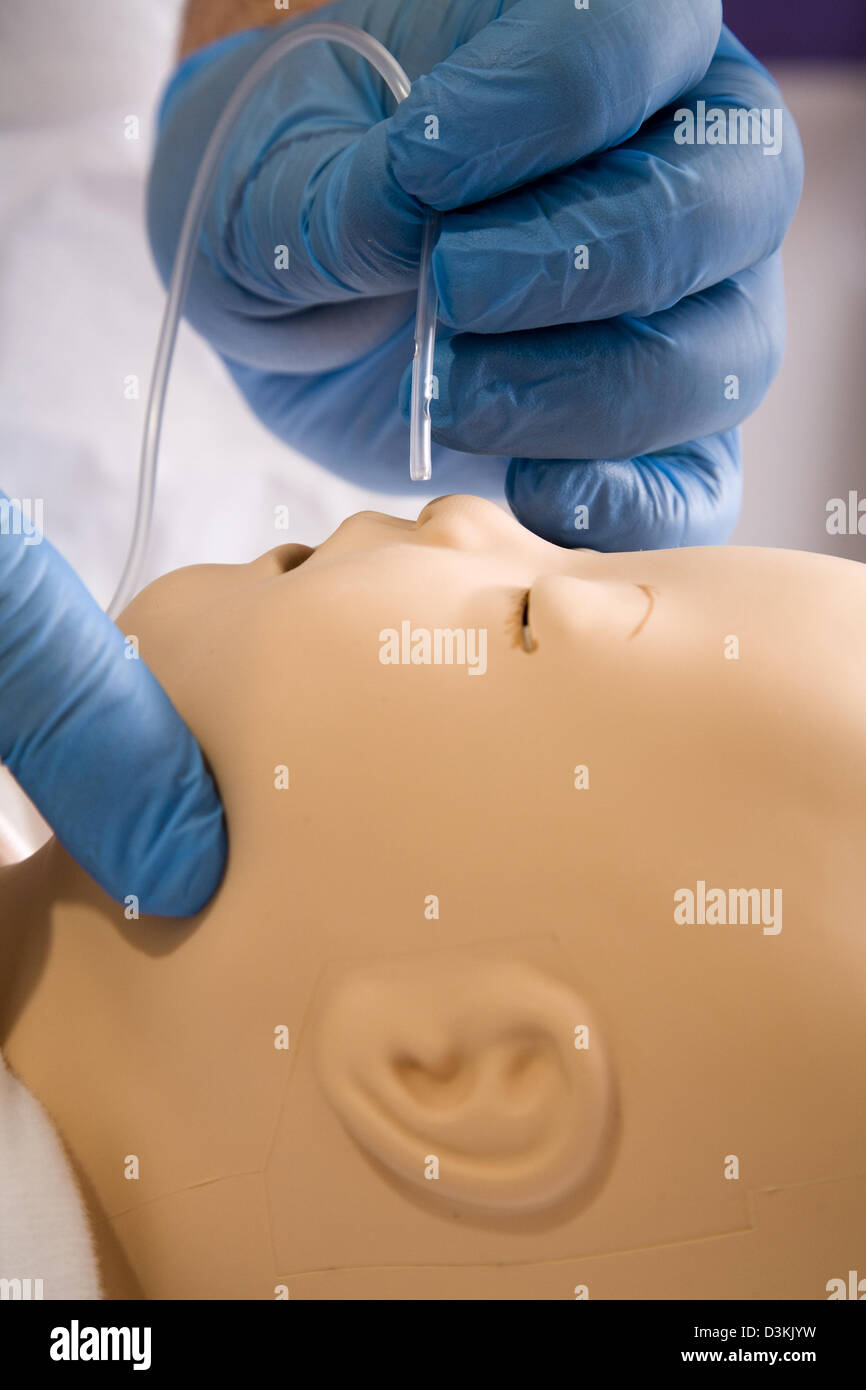 Medico praticare l'inserimento del tubo di aspirazione nel manichino manichino / di un bambino per simulare il ciclo di aspirazione nei bambini. Foto Stock