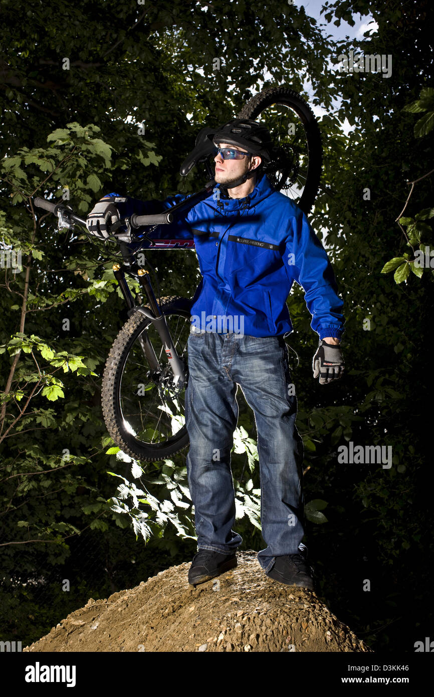 Mountain Biker sta tenendo bike, Esher foresta, Inghilterra Foto Stock