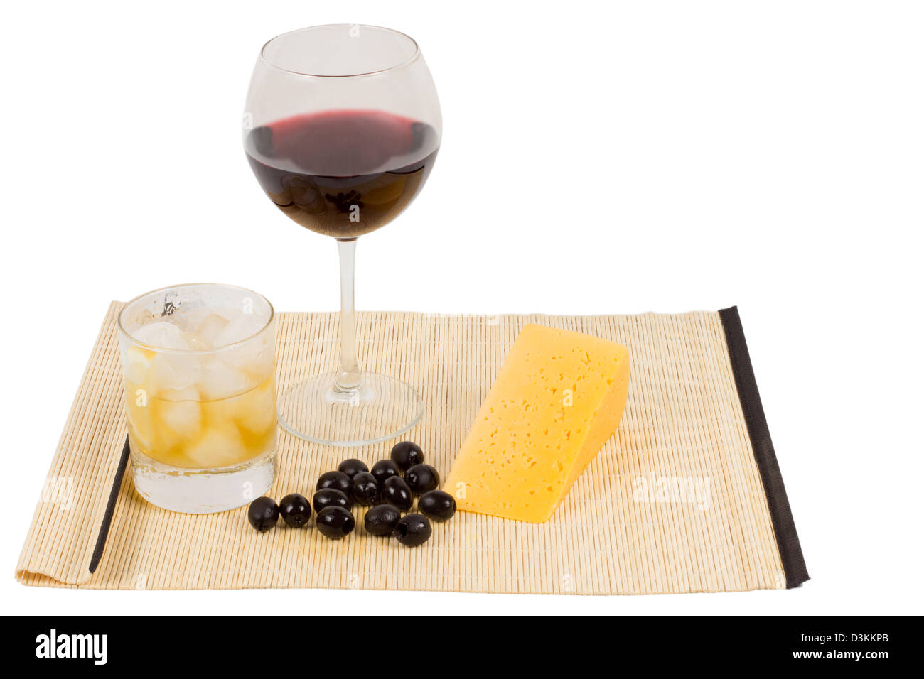 Formaggio e olio d'oliva aperitivo con un bicchiere di vino rosso e un fresco drink ghiacciato in un bicchiere sul lato Foto Stock