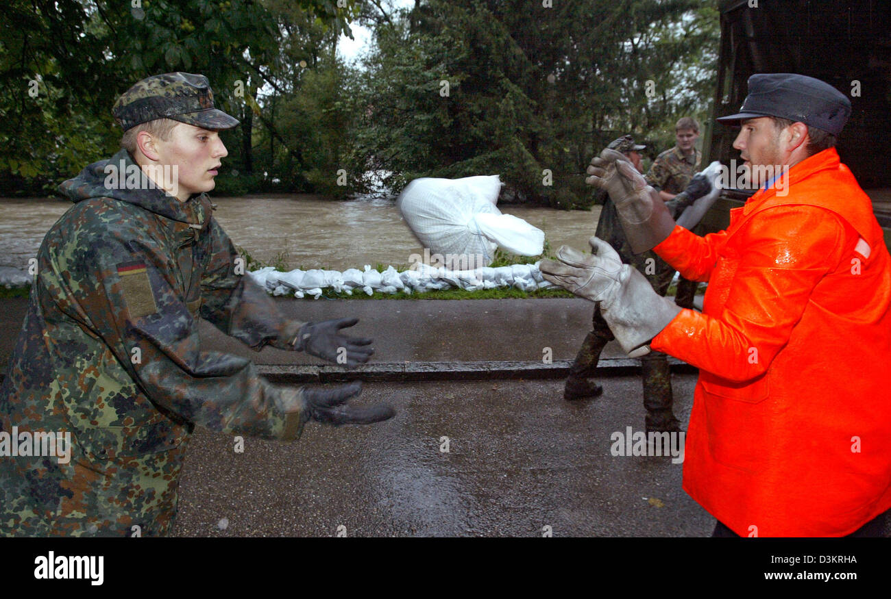 (Dpa) - Membri della Bundeswehr e l'Agenzia federale tedesca per il rilievo tecnico (THW) costruito una parete di protezione da sacchi di sabbia all'Iller banche di Kempten, Germania, 23 agosto 2005. La pioggia continua lasciate che il burst di fiumi in molte parti della regione di Allgaeu. Foto Stock