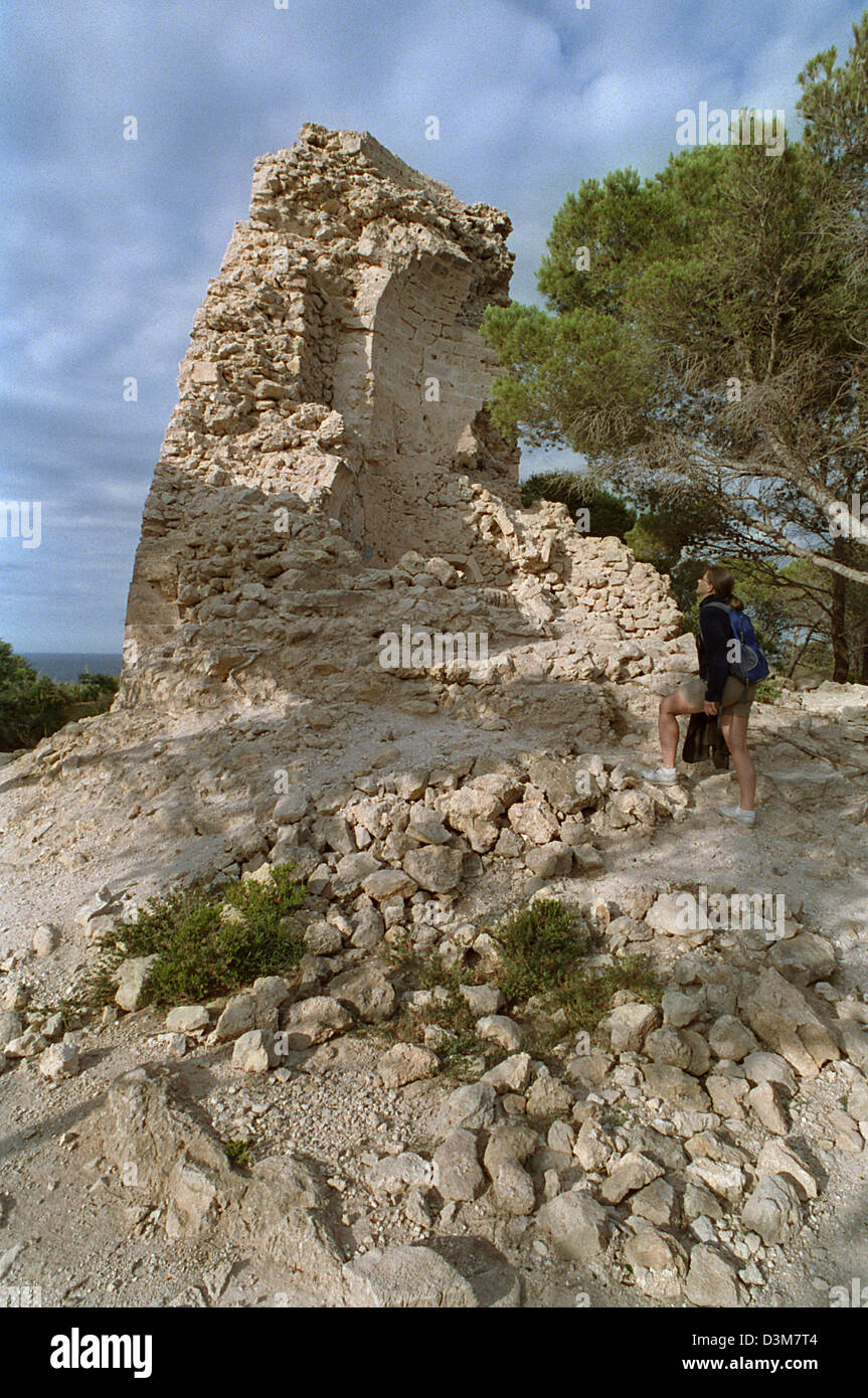 (Dpa) - Un turista guarda la rovina della Torre Embucada torre di avvistamento a Punta de Capdepera a est di Mallorca, Spagna, 28 giugno 2004. Un totale di 85 di queste torri di avvistamento che sono chiamati 'Talaies', esistevano originariamente su tutta l'isola. Nel corso del xvii secolo furono utilizzati come protezione contro gli attacchi dei pirati. Foto: Thorsten Lang Foto Stock