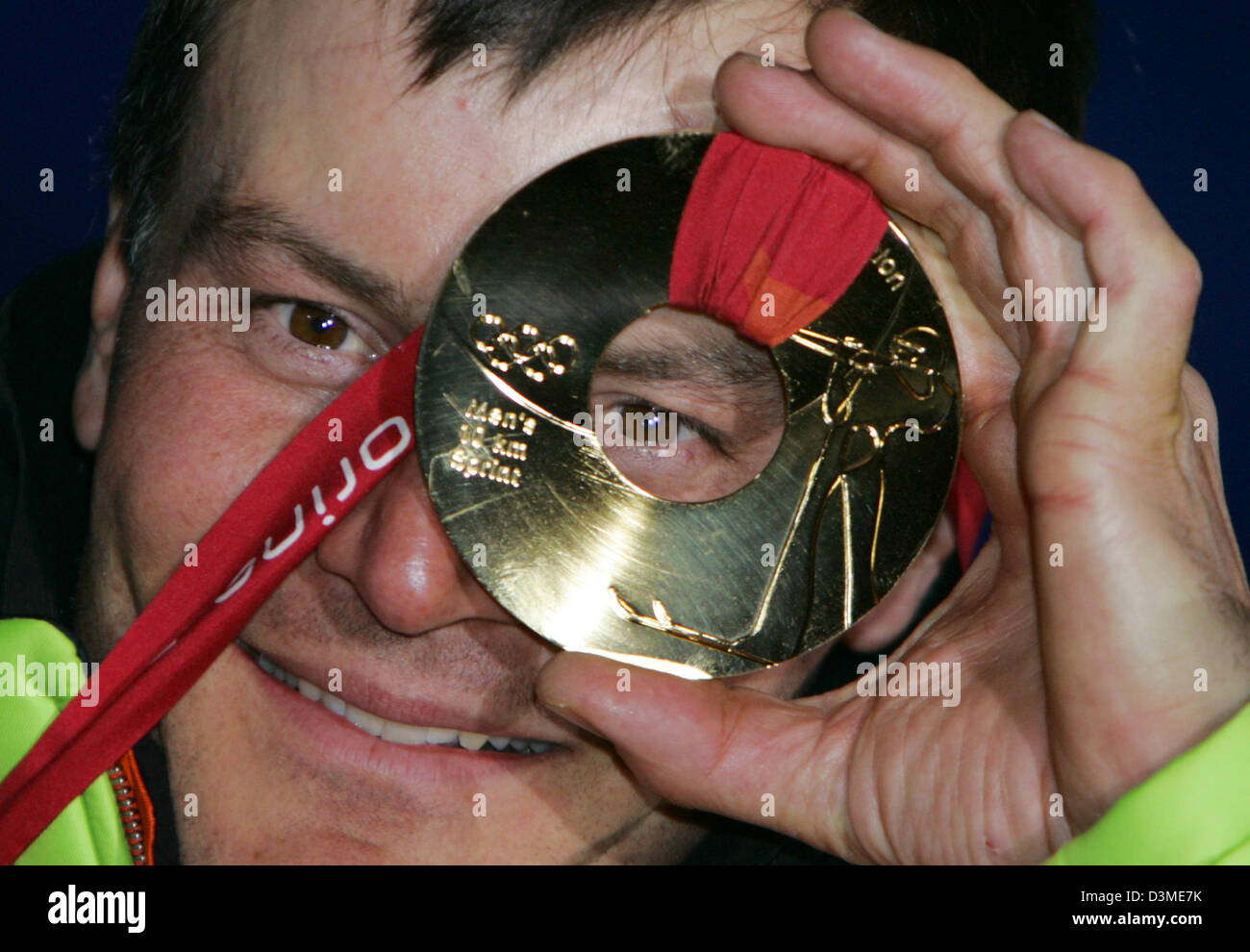 Biatleta tedesco Sven Fischer guarda attraverso un intero nella sua medaglia d'oro olimpica dopo la cerimonia di premiazione si terrà a Torino, Italia, Martedì, 14 febbraio 2006. Fischer ha vinto il maschile di biathlon event oltre dieci chilometri. Foto: Frank può Foto Stock