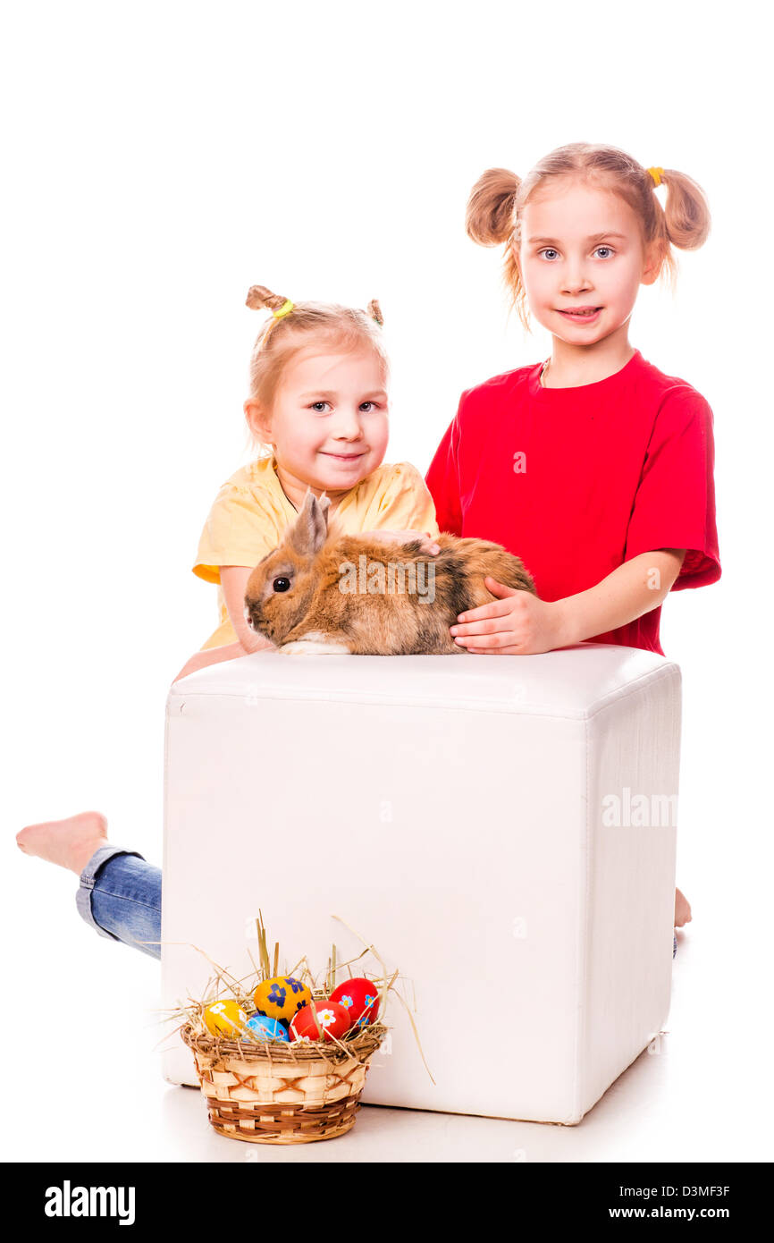 Due bambini felici con il coniglietto di pasqua e uova isolate su bianco. Buona Pasqua Foto Stock