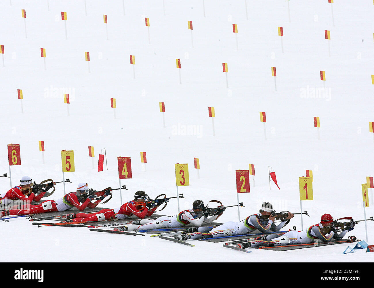 Biatleti sparare mentre giaceva a terra presso il poligono di tiro durante la 15 km sprint di massa presso i Giochi Olimpici Invernali a San Sicario, Italia, sabato 25 febbraio 2006. Medaglia d'oro Michael Greis con il numero 1 è raffigurato nella parte anteriore (R) accanto a Sven Fischer. Foto: Martin Schutt Foto Stock