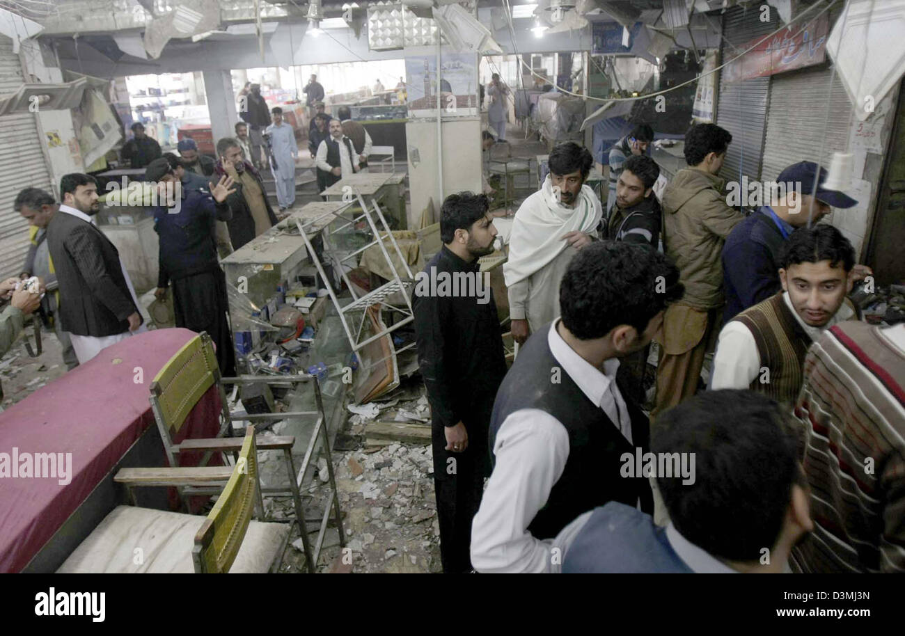 Le persone si radunano presso il sito e il relitto del distrutto negozi visto dopo l esplosione di una bomba al mercato della telefonia mobile in area Hashtnagri nella città di Peshawar giovedì, 21 febbraio 2013. Almeno una persona è stata uccisa mentre 18 altri sono stati feriti quando un'esplosione strappato attraverso un affollato mercato dei cellulari a Peshawar. Alcuni negozi sono stati anche distrutti in esplosione che è stato piantato all'interno del mercato. Foto Stock