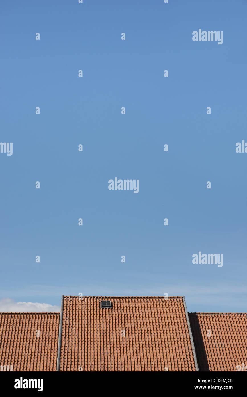 Esterno dell edificio, tetto con piastrelle di ceramica e di una piccola finestra sotto un cielo blu chiaro Foto Stock
