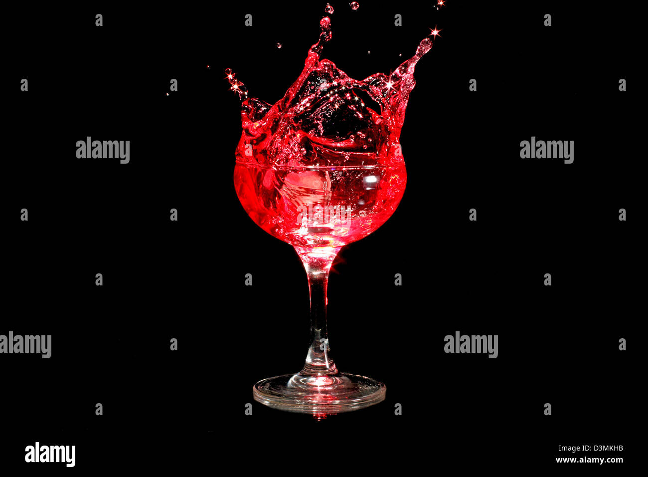 Il cubo di ghiaccio spruzzi in un bicchiere di vino Foto Stock