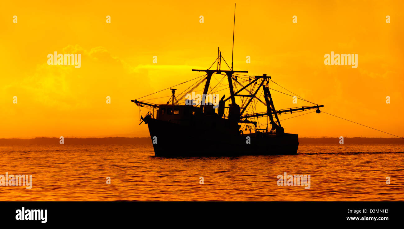 Barca da pesca silhouette arancione tramonto mare Trinidad e Tobago al crepuscolo Foto Stock