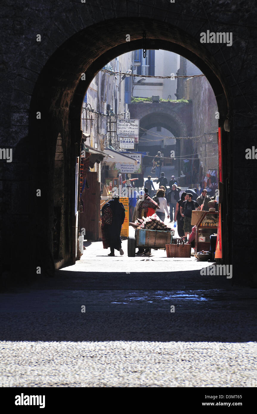 Visualizzazione attraverso l'arco di mercato gli operatori nella Medina nel medievale città murata di Essaouira sulla costa atlantica del Marocco Foto Stock
