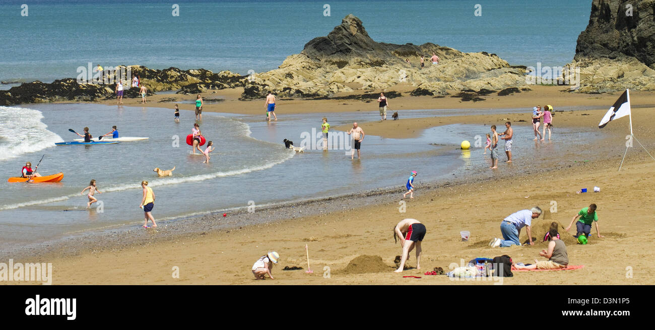 Persone responsabili delle vacanze godendo le estati calde giornata sulla spiaggia di Aberporth in Galles Ceredigion Foto Stock