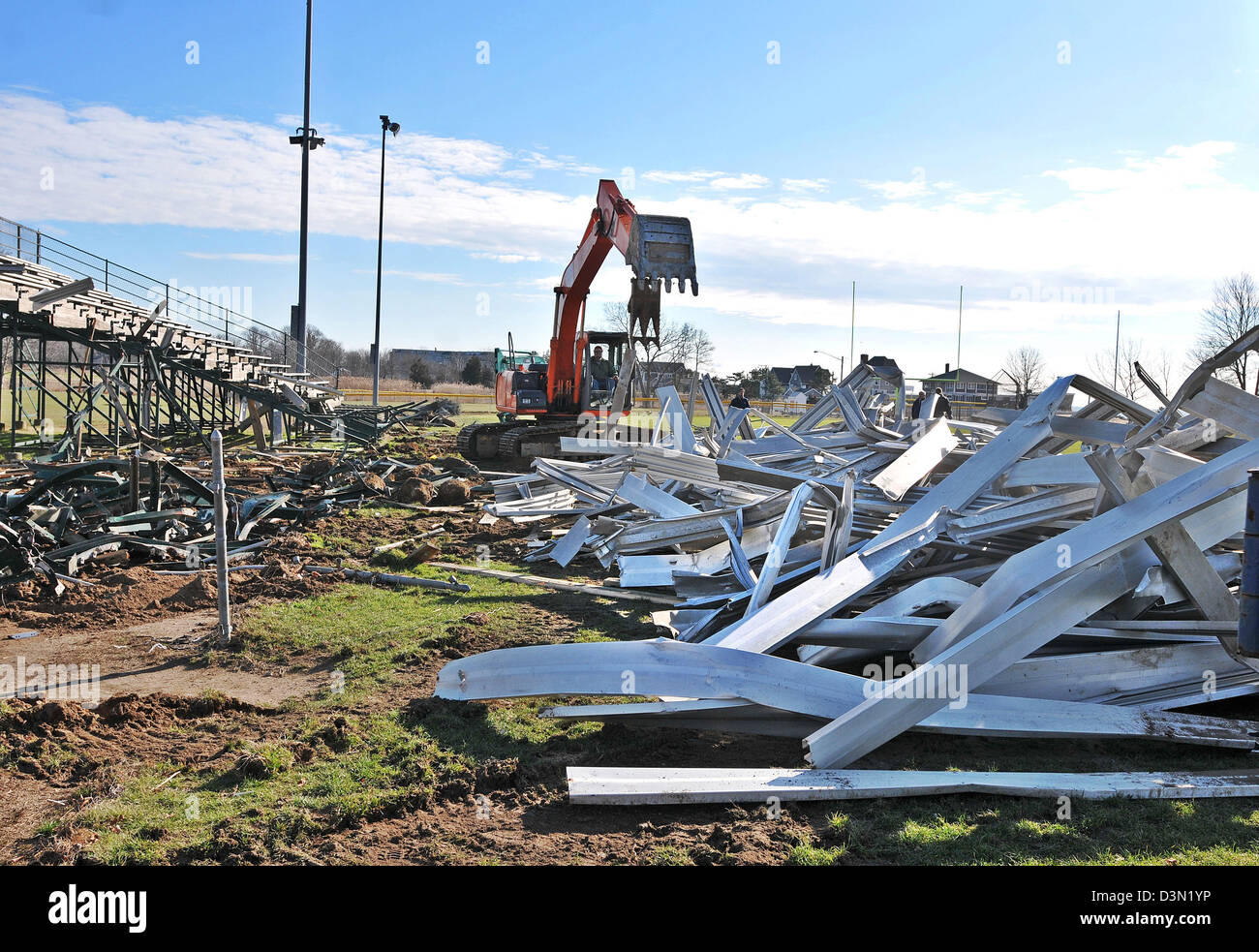 Un wrecker abbatte le gradinate in uno stadio di calcio in Madison CT USA come la città si prepara a costruire una nuova. Foto Stock