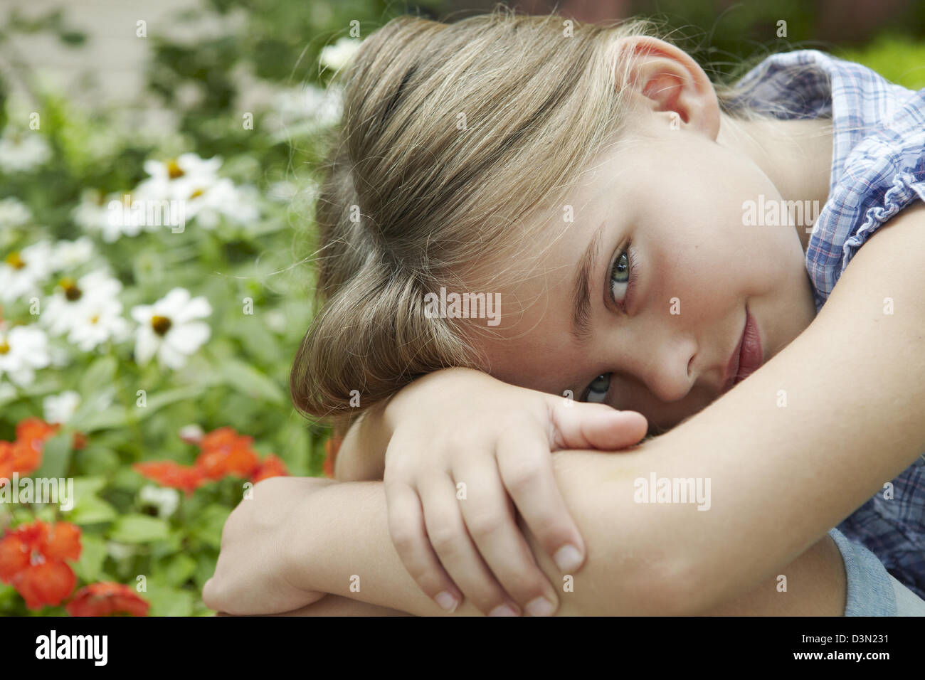7 anno vecchia ragazza abbracciando le ginocchia Foto Stock