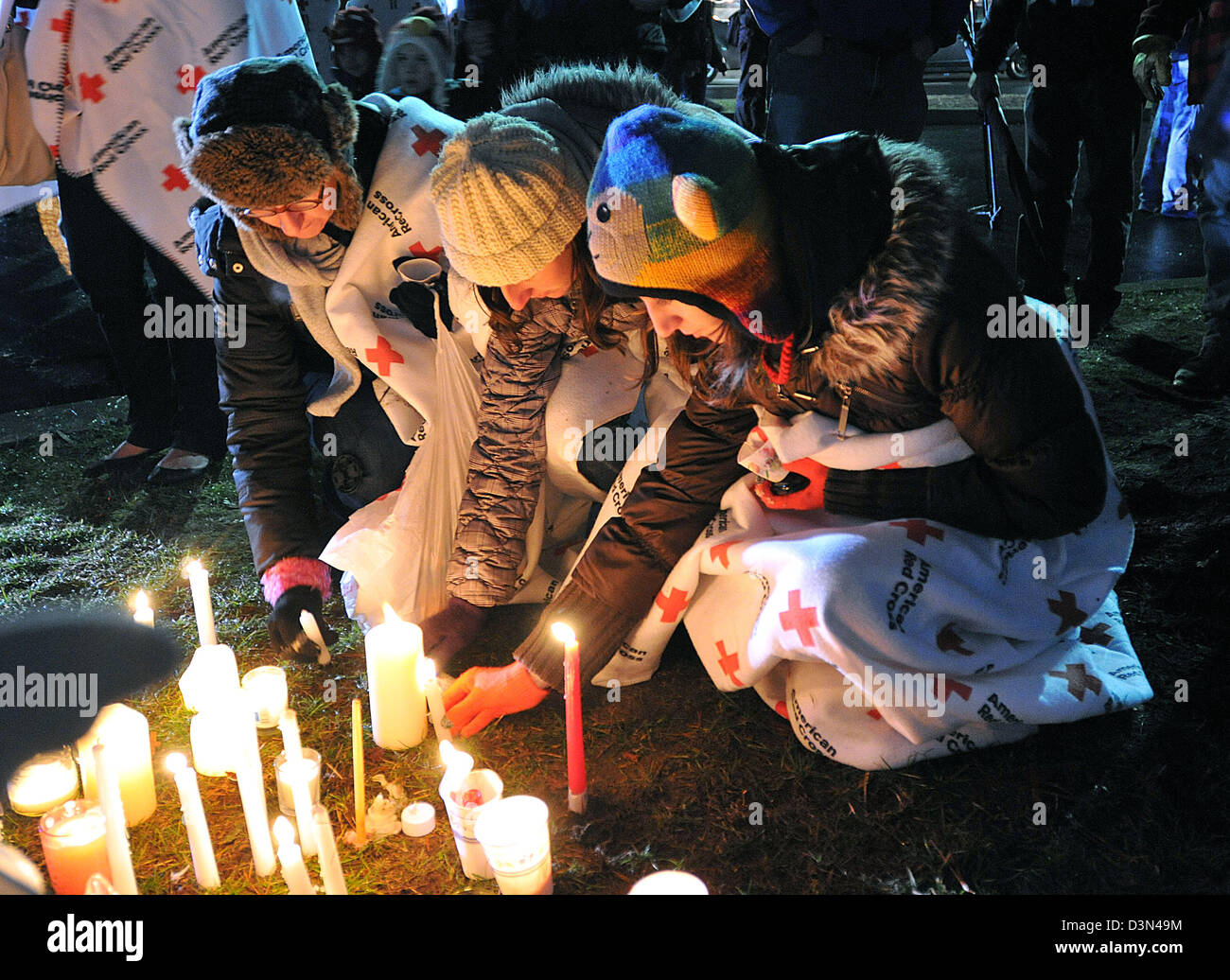 Persone in lutto accendono le candele durante una veglia a Newtown High School a seguito del Sandy Hook riprese spree in CT STATI UNITI D'AMERICA Foto Stock