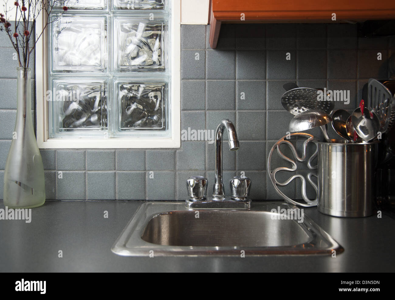 Lavello da cucina e utensili sul bancone accanto al lavandino Foto Stock