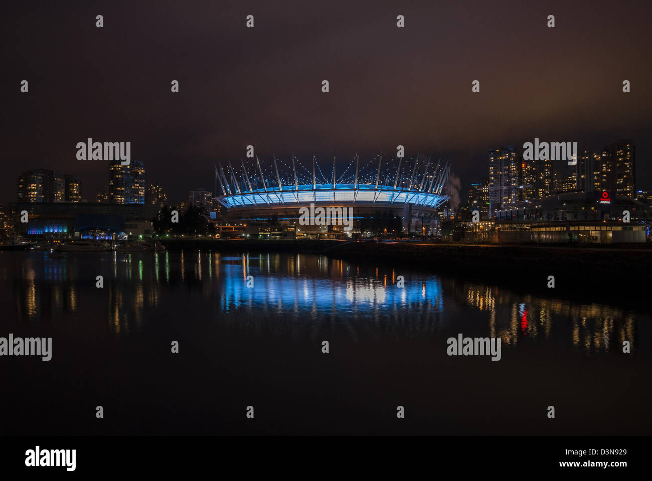 Foto notturne di BC Place Stadium di Vancouver, BC, Canada con la riflessione nelle acque di False Creek. Foto Stock