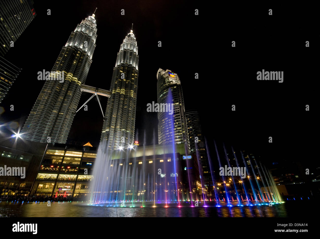 Petronas Twin Towers di Kuala Lumpur a notte con fontana nella parte anteriore Foto Stock