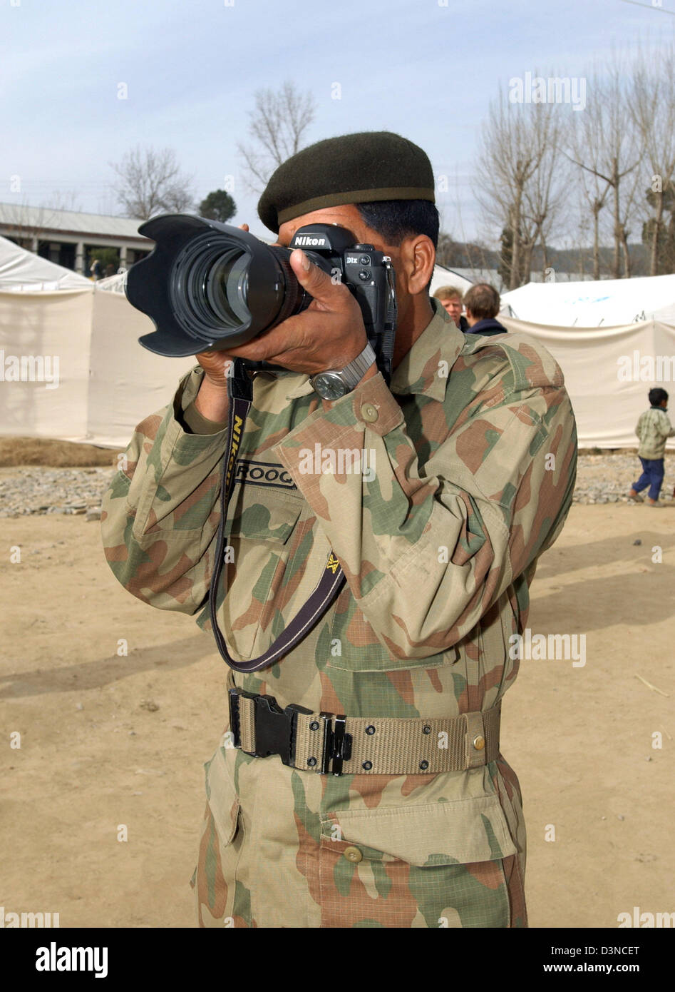 Un funzionario pakistano guarda attraverso il mirino della fotocamera in un campo di rifugiati nella città di Balakot, Pakistan, Mercoledì, 01 febbraio 2006. Milioni di persone hanno subito in seguito a un terremoto che ha colpito in ottobre 2005 colpendo la Provincia del Kashmir. Foto: Wolfgang Langenstrassen Foto Stock