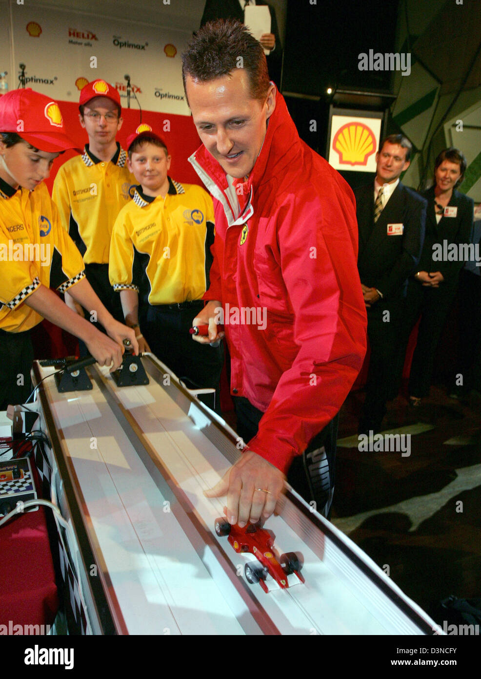 Il tedesco pilota di Formula Uno Michael Schumacher (anteriore R) della Scuderia Ferrai F1 team gioca con un modello di vettura da corsa dopo la conferenza stampa per la Australian Grand Prix 2006 a Melbourne, Australia, Mercoledì, 29 marzo 2006. Il Grand Prix 2006 avviene la Domenica, 02 aprile 2006. Foto: Rainer Jensen Foto Stock