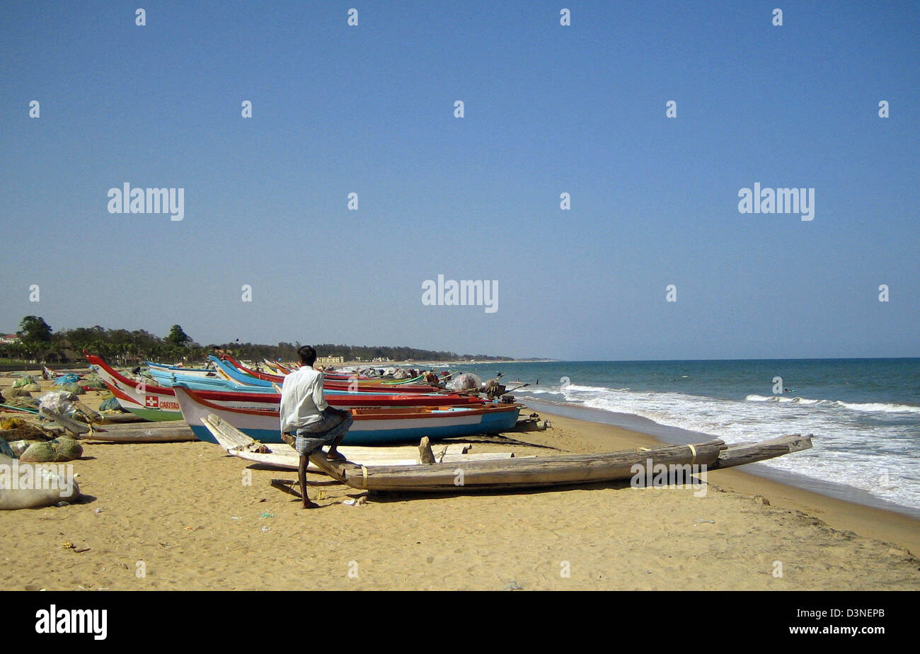 (Dpa) file - un pescatore guarda le barche da pesca in una spiaggia sulla costa di Coromandel vicino a Mahabalipuram (Mamallapuram) nello stato di Tamil Nadu, India, 25 febbraio 2006. La maggior parte delle barche sono state finanziate da diversi donatori di aiuti dopo la tsumami aveva colpito la costa in dicembre 2004 e ha provocato numerose vittime nonché ingenti danni alla proprietà. Foto: Beate Schleep Foto Stock