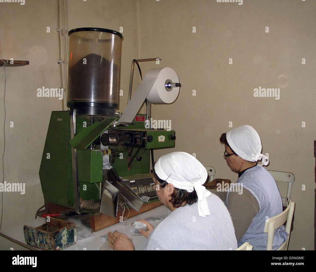 (Dpa) file di due donne che lavorano ad una macchina per il riempimento di bustine di tè, Sao Miguel, Azzorre, Portogallo, 04 aprile 2005. 30-40 tonnellate di tè nero e verde sono prodotte su questa piantagione, probabilmente unica in Europa. Foto: Juergen Darmstaedter Foto Stock