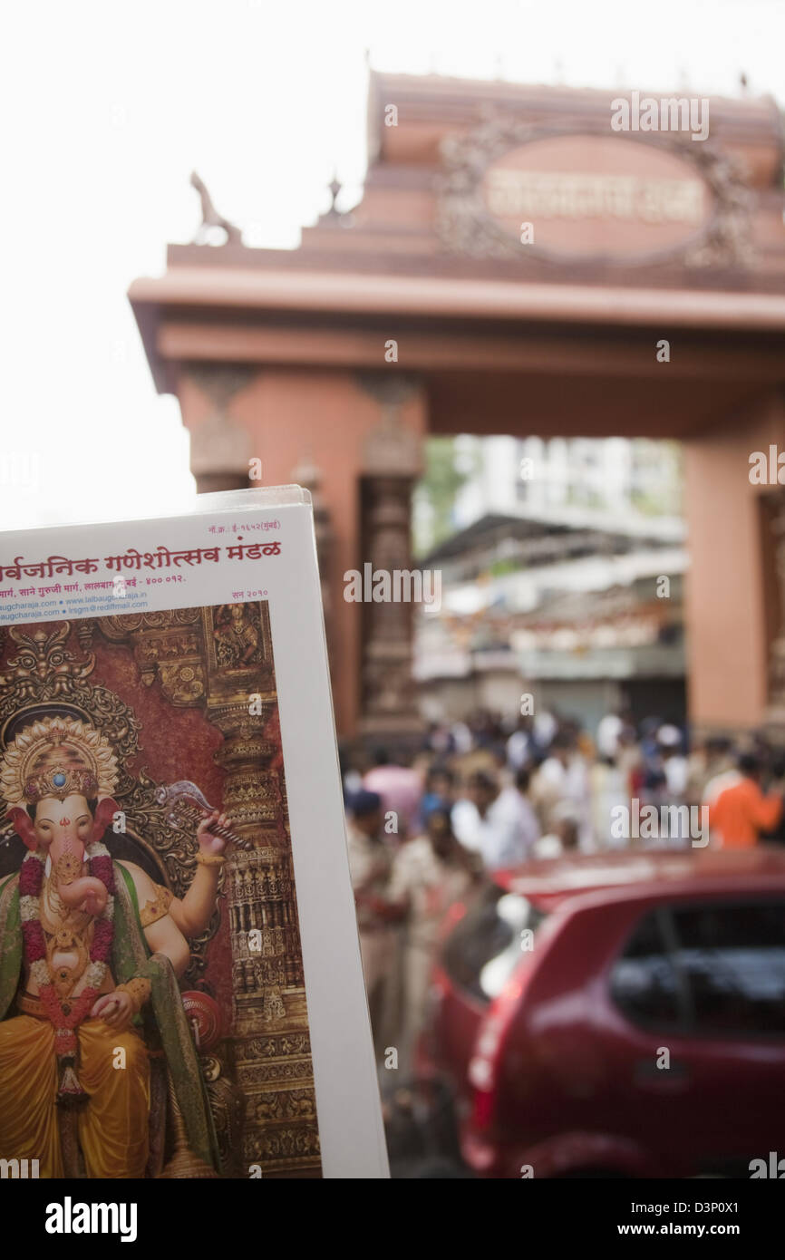 Poster del Signore Ganesh con la folla in un tempio in background, Mumbai, Maharashtra, India Foto Stock