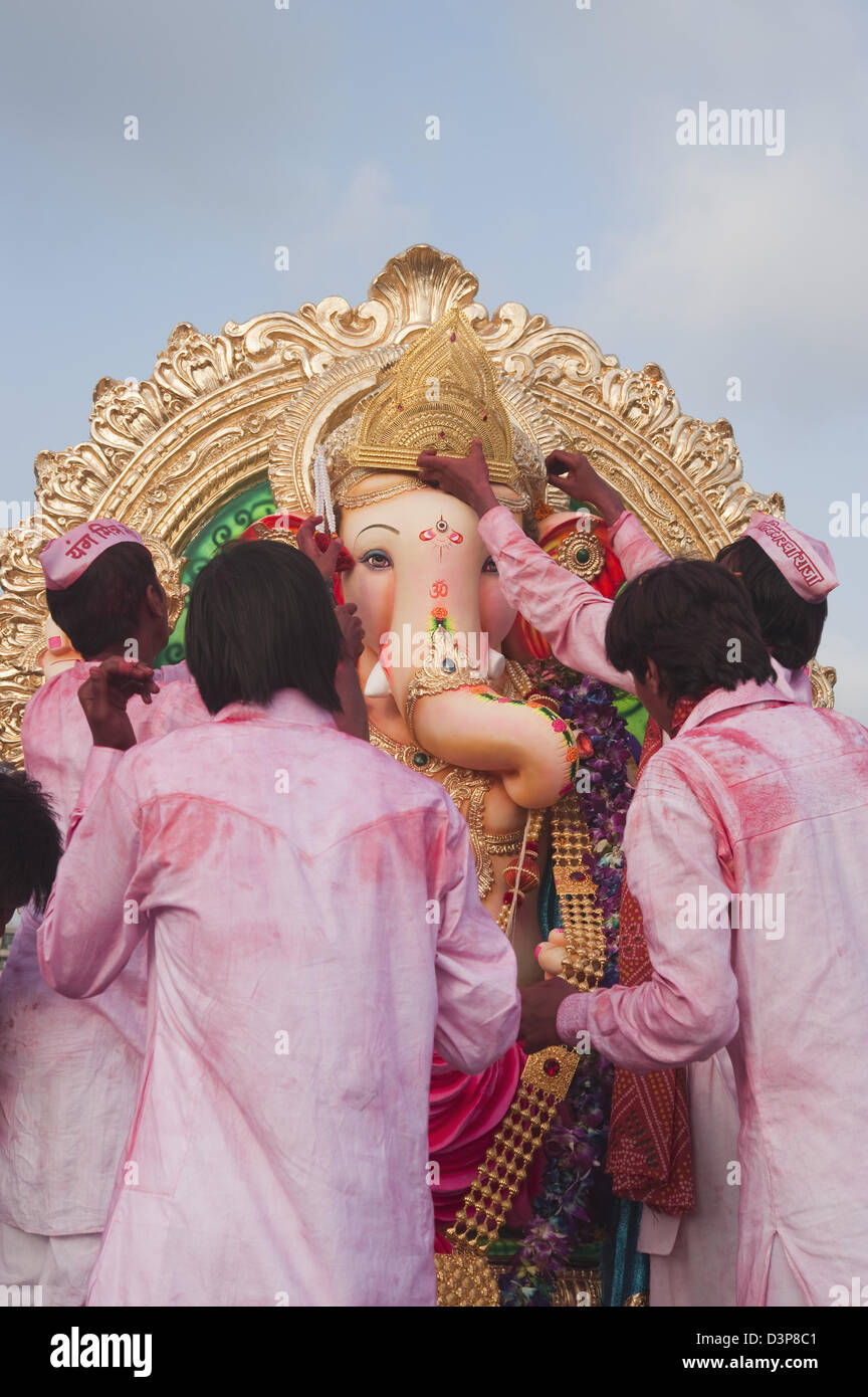 Persone adorare idol del signore Ganesha alla cerimonia di immersione, Mumbai, Maharashtra, India Foto Stock