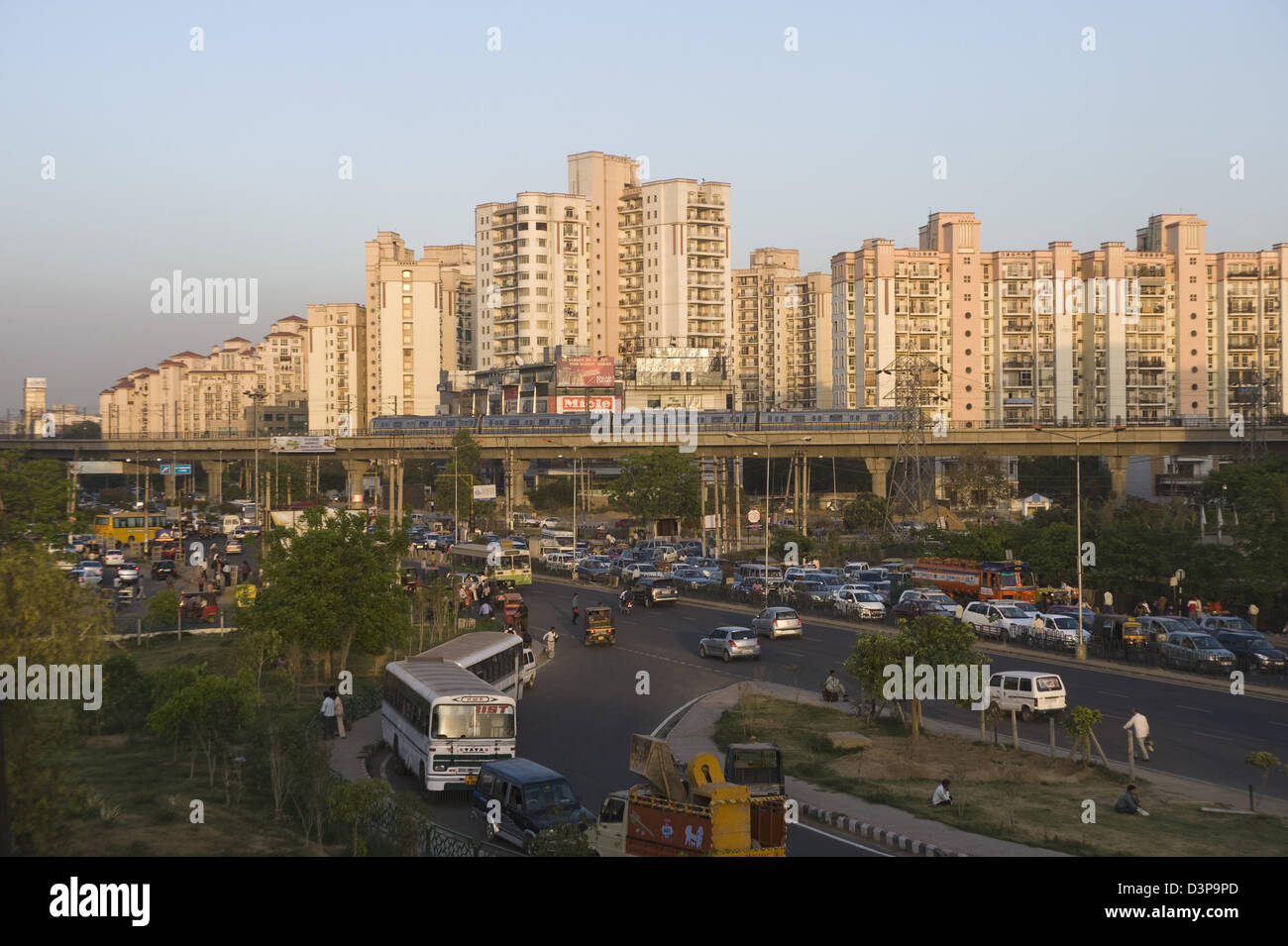 Il traffico su strada con il treno della metropolitana e appartamenti residenziali in background, IFFCO Chowk, Gurgaon, Haryana, India Foto Stock