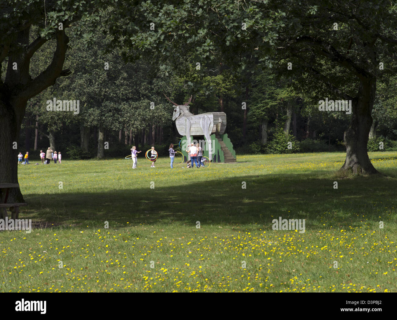 Bambini che giocano in legno la figura di un cervo a Thetford Forest picnic Foto Stock
