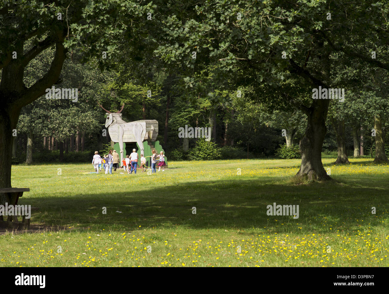 Bambini che giocano in legno la figura di un cervo a Thetford Forest picnic Foto Stock