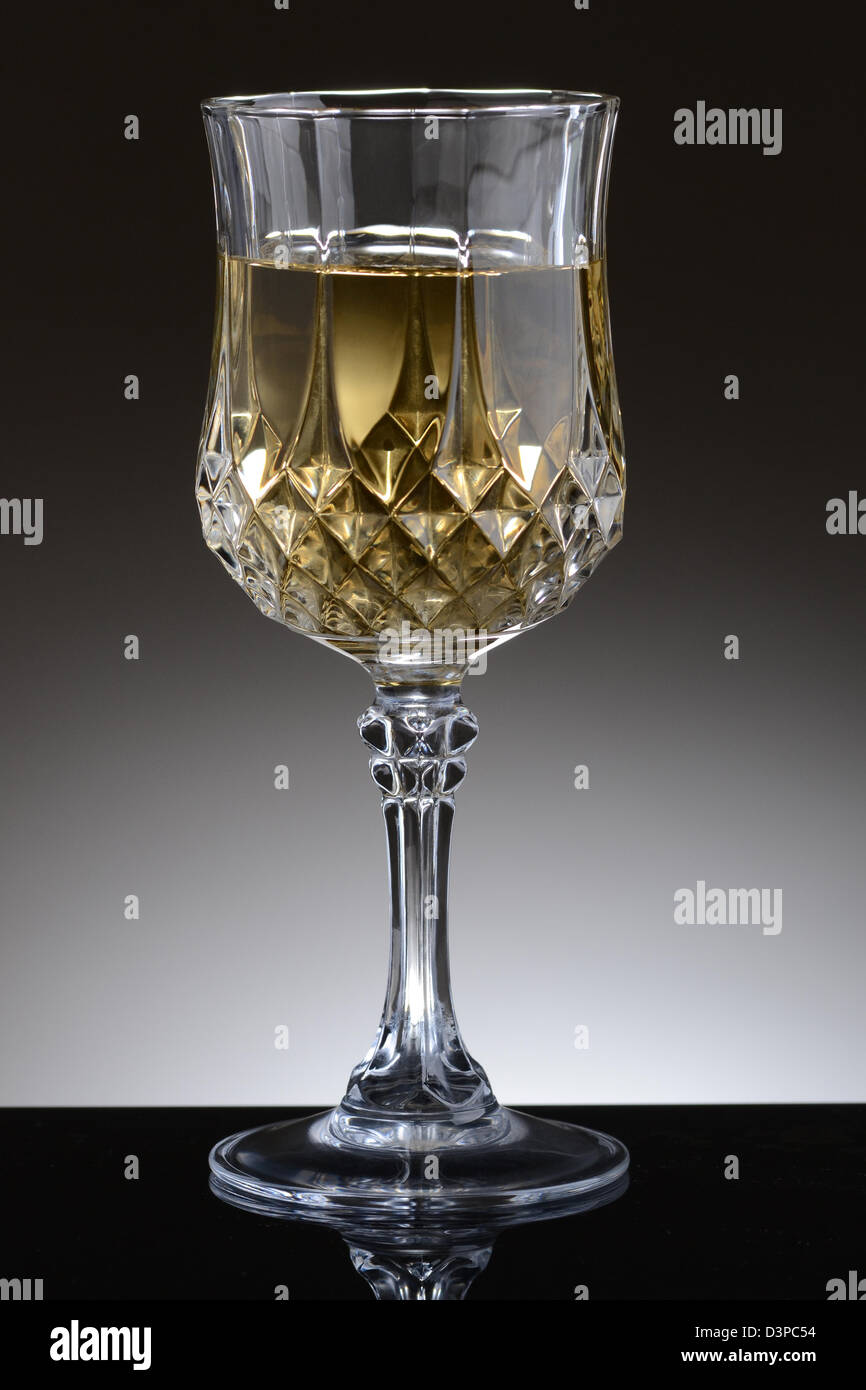 Primo piano di un delizioso bicchiere di vino chardonnay su una luce di sfondo grigio scuro. Foto Stock