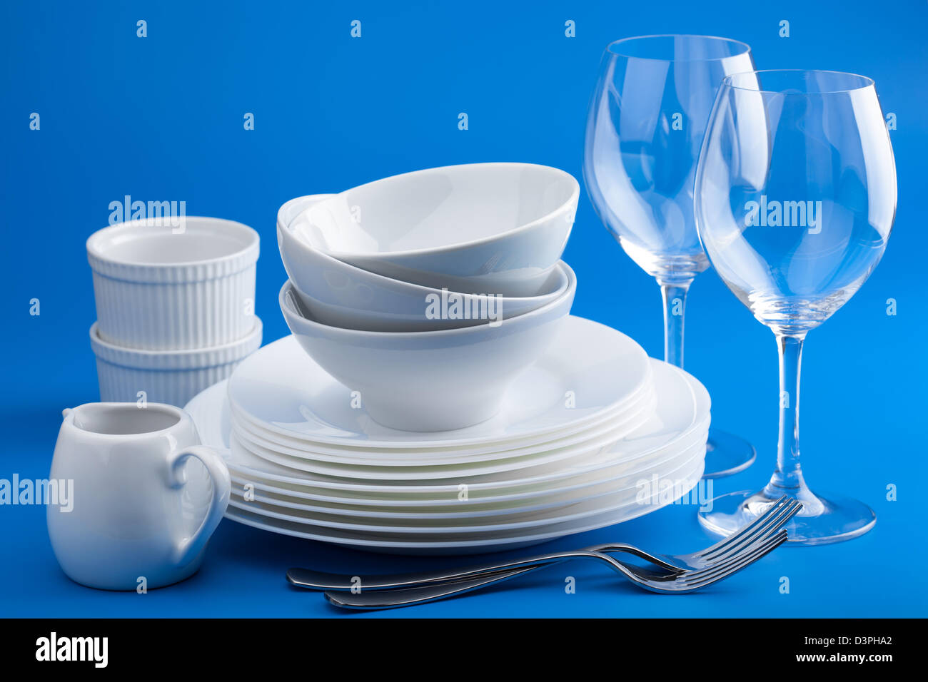 Oggetti per il servizio da tavola bianco su sfondo blu Foto Stock