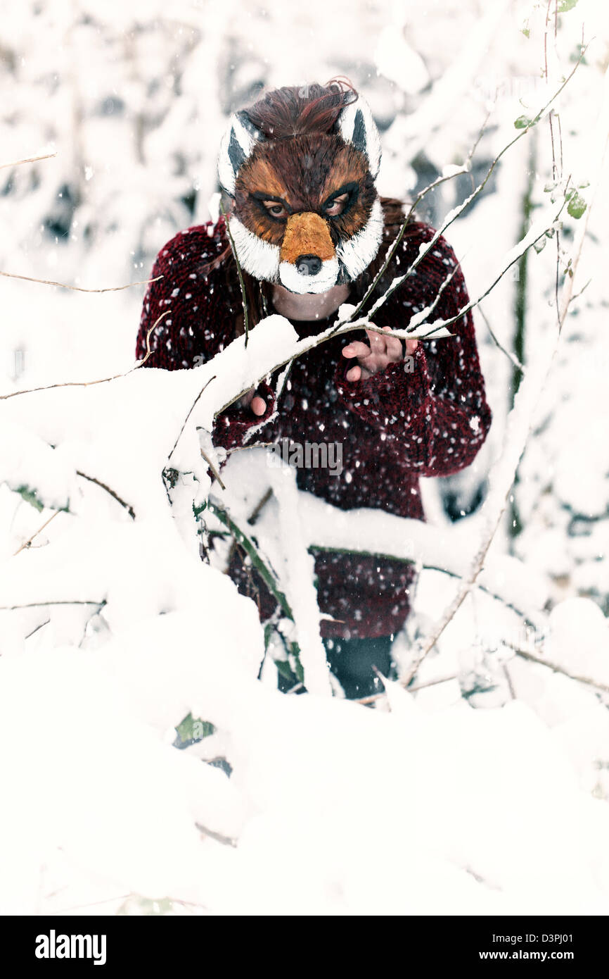 Donna che indossa un mascheramento fox nella neve Foto Stock