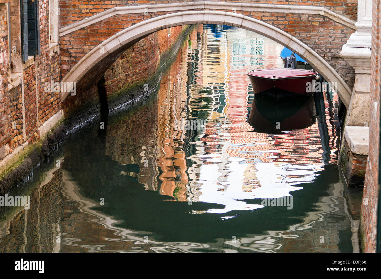 Riflessioni al di sotto di un ponte su un canale di Venezia Foto Stock