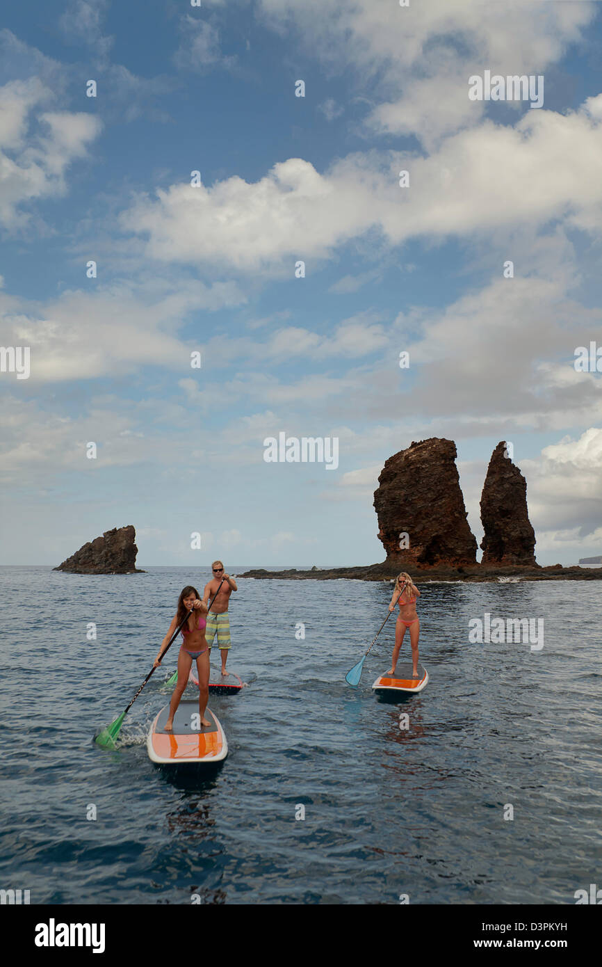 Tre giovani in stand up paddle boards in corrispondenza degli aghi al largo dell'isola di Lanai, Hawaii. Tutti e tre sono del modello rilasciato. Foto Stock