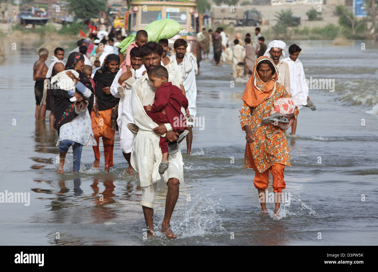 Muzaffargarh, Pakistan, persone wade attraverso strade inondate da Foto Stock