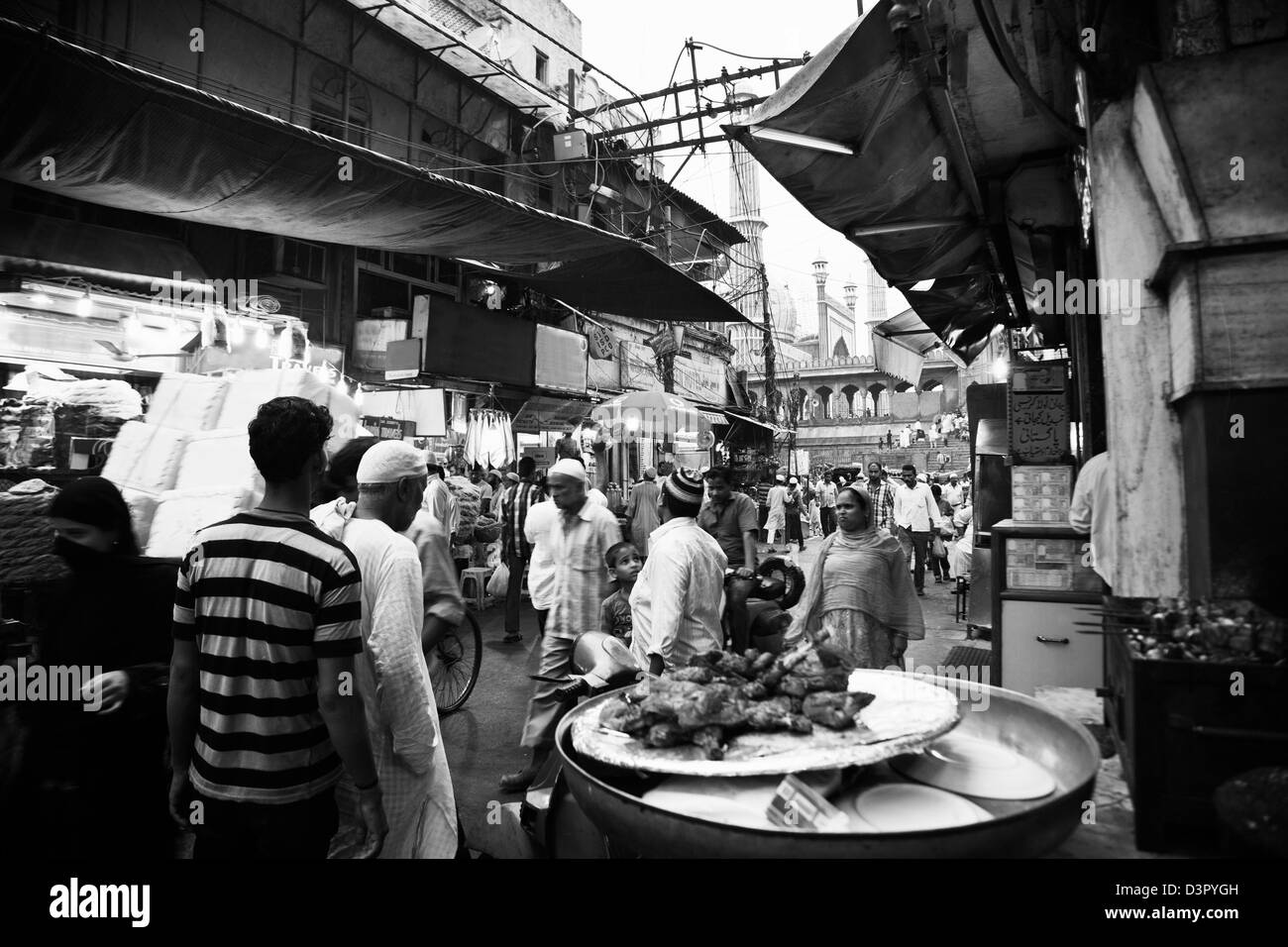 Strada del mercato con una moschea in background, Jama Masjid, la Vecchia Delhi, Delhi, India Foto Stock